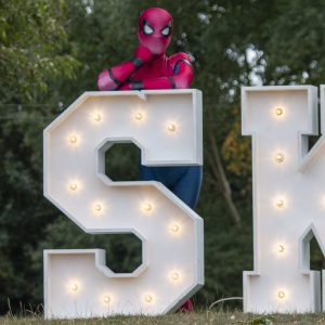 Spiderman costume character posing at the SkyFest illuminated Signage