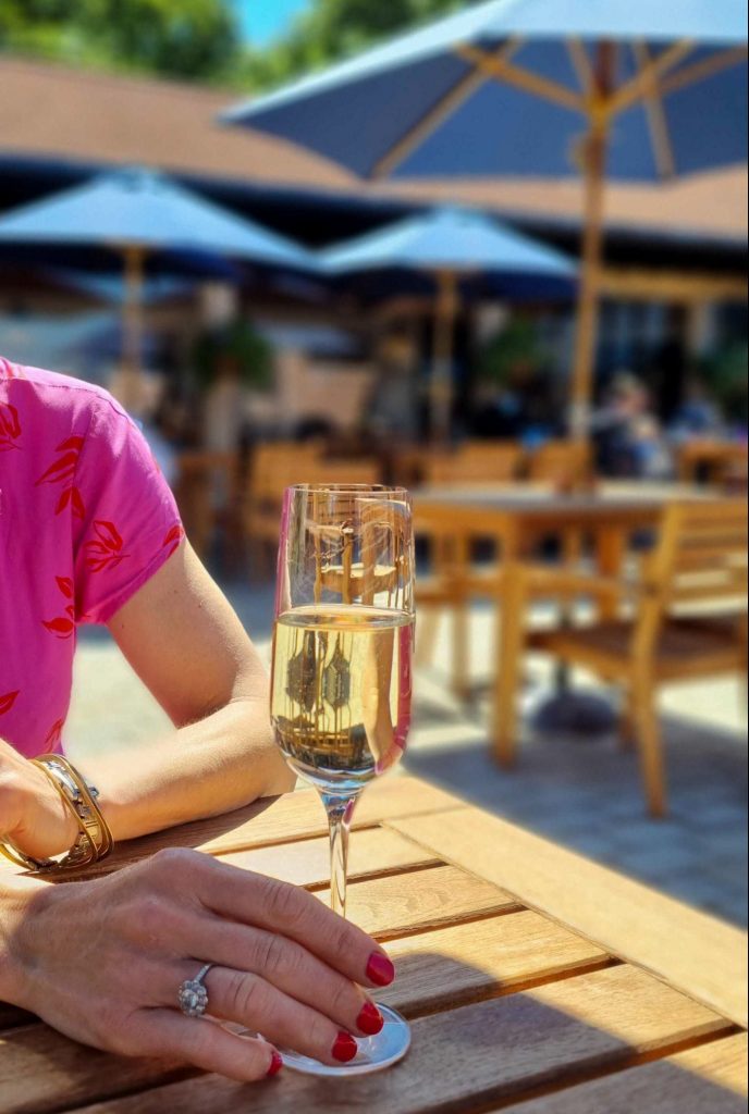 Glass of Tinwood sparkling being enjoyed outside in the Courtyard at Sky Park Farm