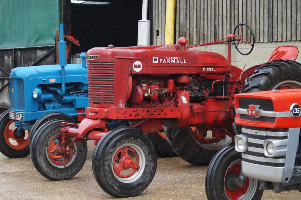 Image of three vintage tractors in a car park