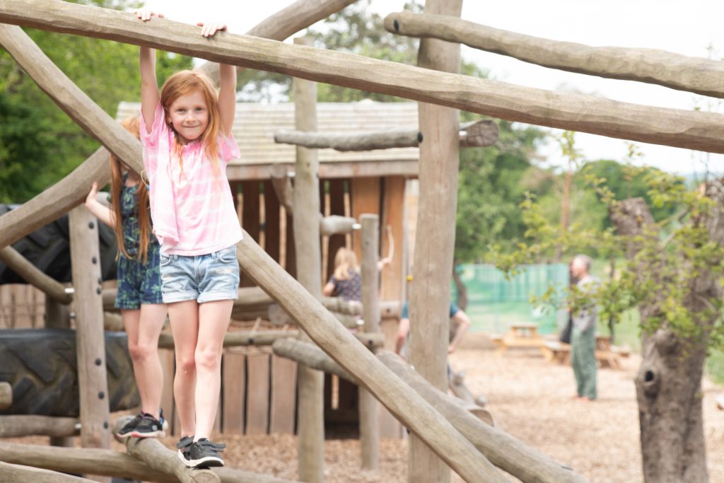 two children walking along climbing frame in sky park farm adventure playground